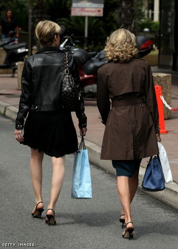 Two women with shopping bags walk down a side street near the Croisette Two women with shopping bags walk down a side street near the Croisette