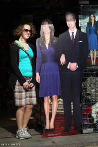 Hummmm... a tourist stands next to a cardboard cutout photograph of Prince William and Kate Middleton outside a souvenir shop.